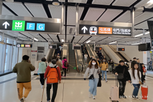 Menschen mit Gepäck durch einen geschlossenen Flughafen gehen, Rolltreppen, Informationsanzeigen, Deckenleuchten und Glaswände im Hintergrund.