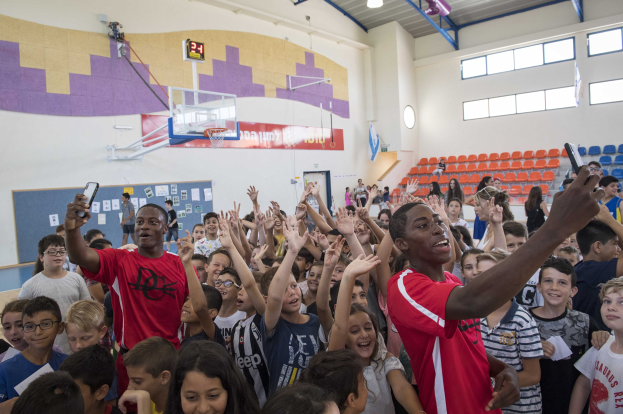 Kinder vor einem Basketballfeld mit Handys stehend