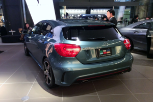 Ein Mercedes-Benz A-Klasse Hatchback auf der IAA in Frankfurt, ein schlankes, modernes Design mit glänzender schwarzer Lackierung und Chromakzenten, umgeben von einer Gruppe von Menschen.