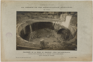 Schwarzes und weißes Foto eines Tunnels im Bau mit einem Stempel links und Text unten.