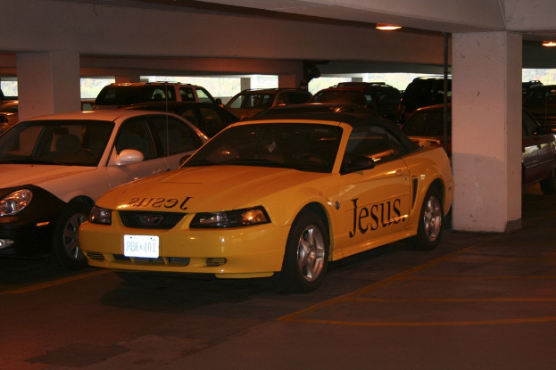 Ein vollbesetztes Parkplatz mit zahlreichen geparkten Autos vor einem Geb├Ąude.