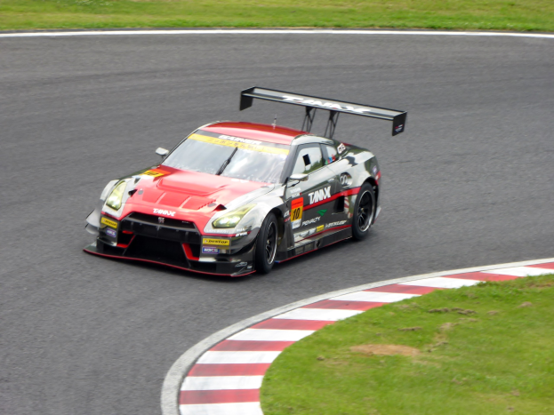 Nissan GT-R Nismo GT3-Rennwagen auf der Nürburgring 24 Stunden-Strecke mit grünem Gras auf beiden Seiten.