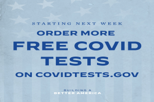 Ein Plakat mit der Aufschrift "Ab nächster Woche mehr kostenlose Covid-Tests auf CovidTests.gov" in fetter, weißer Schrift auf blauem Hintergrund.