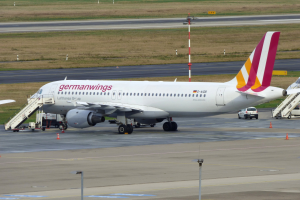 Germanwings Airbus A320-200 auf dem Frankfurt Airport geparkt mit Bodenfahrzeugen, Verkehrskegeln, Pfosten und Gras im Hintergrund.